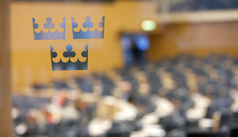 Svensk myndighetsmiljö med riksvapnet på glasvägg.