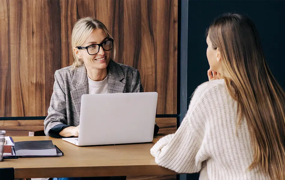 Samtal mellan två personer vid ett skrivbord.
