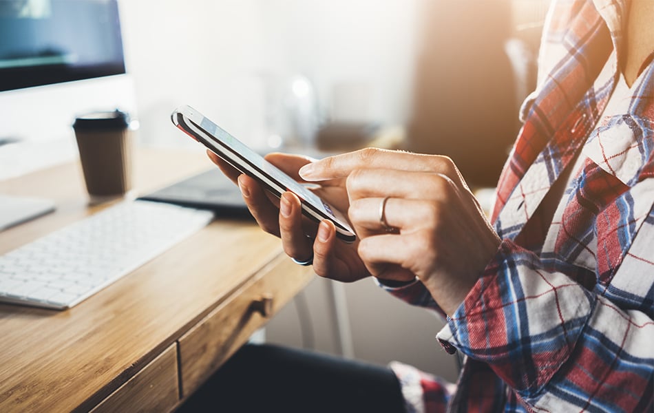 Närbild på en hand som håller i en telefon