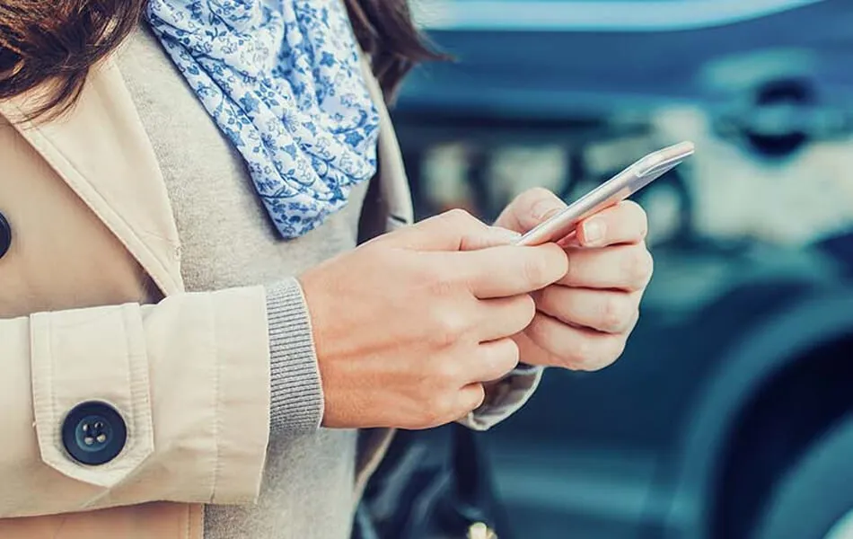 Kvinna fyller i sin digitala körjourna på sin mobiltelefonl