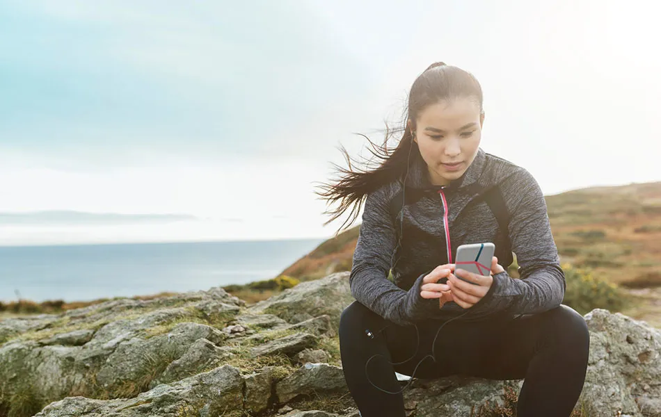 Kvinna på fjället med mobiltelefon