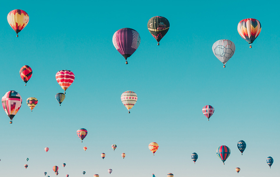 Aspia - Vårt erbjudande - stort antal luftballonger täcker blå sommarhimmel.